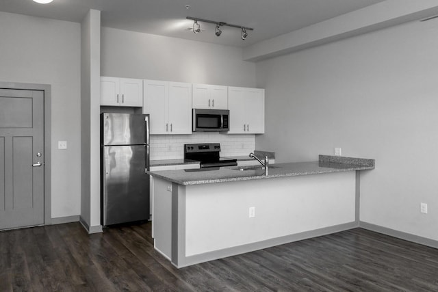 kitchen featuring white cabinetry, tasteful backsplash, stainless steel appliances, and kitchen peninsula