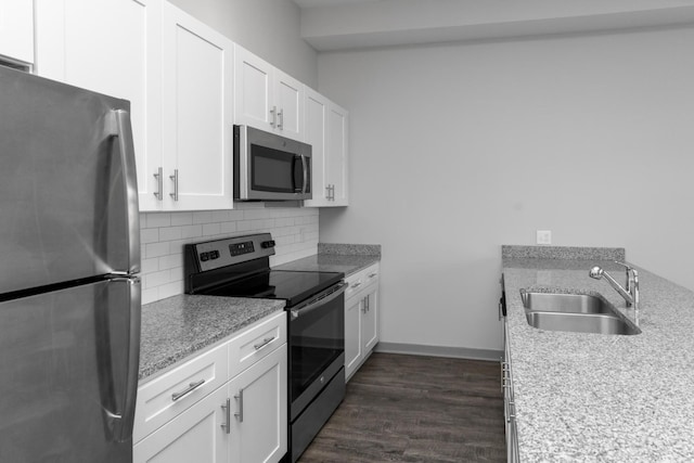 kitchen featuring sink, white cabinetry, stainless steel appliances, dark hardwood / wood-style flooring, and decorative backsplash