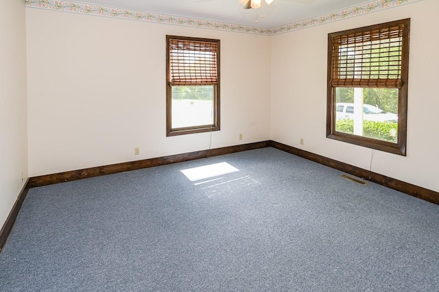 carpeted spare room with ceiling fan