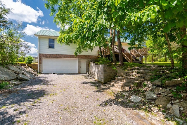 view of property exterior with a garage and a deck