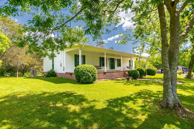 back of house featuring covered porch and a lawn