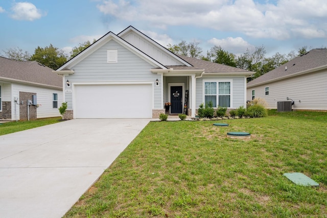 view of front of home with a garage, central AC, and a front yard