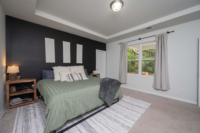 carpeted bedroom with a tray ceiling