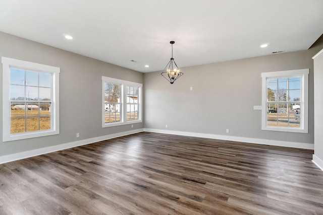 unfurnished room with dark hardwood / wood-style flooring and a chandelier
