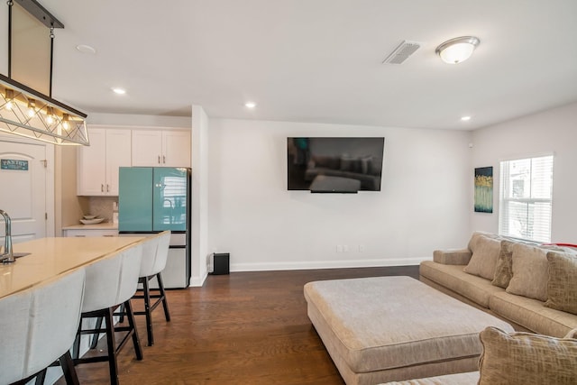 living room featuring sink and dark hardwood / wood-style floors