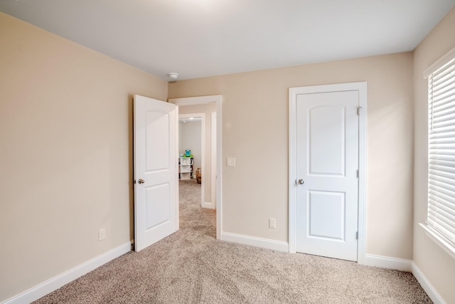 unfurnished bedroom featuring light carpet