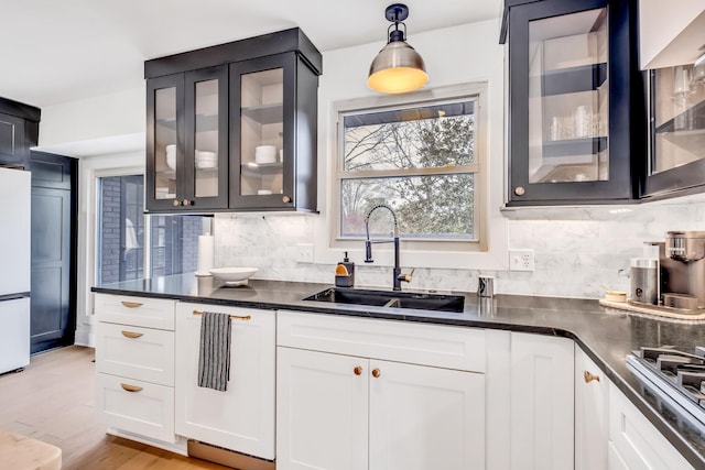 kitchen with pendant lighting, sink, white cabinets, backsplash, and white refrigerator