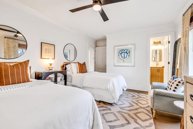 bedroom featuring ceiling fan, ensuite bathroom, light hardwood / wood-style floors, and ornamental molding