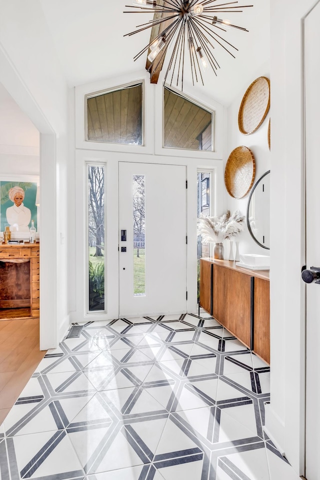 entryway featuring an inviting chandelier and vaulted ceiling