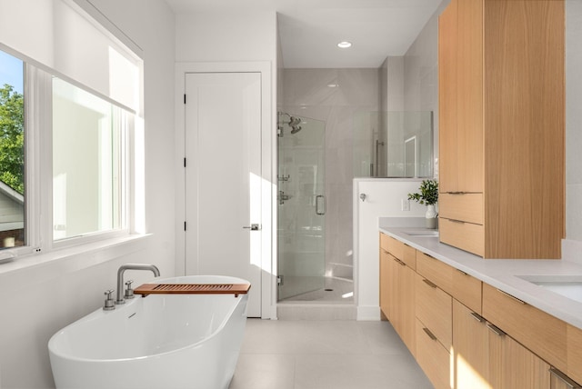 bathroom featuring plus walk in shower, vanity, and tile patterned floors