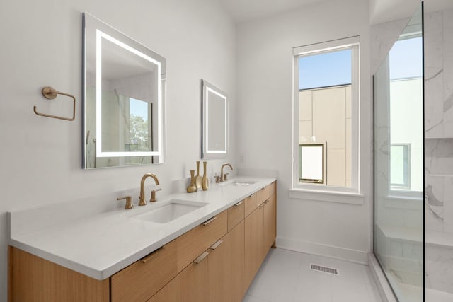 bathroom featuring tile patterned floors, vanity, and a tile shower