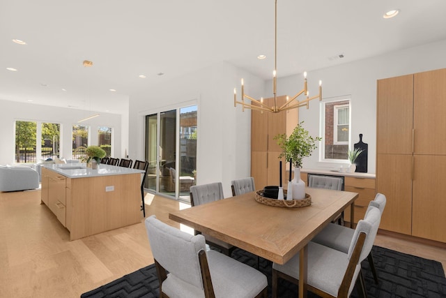 dining space featuring light hardwood / wood-style flooring and a chandelier