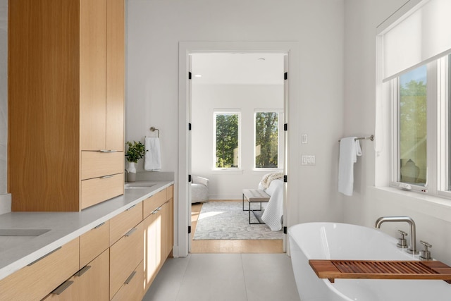 bathroom featuring vanity, tile patterned flooring, and a washtub