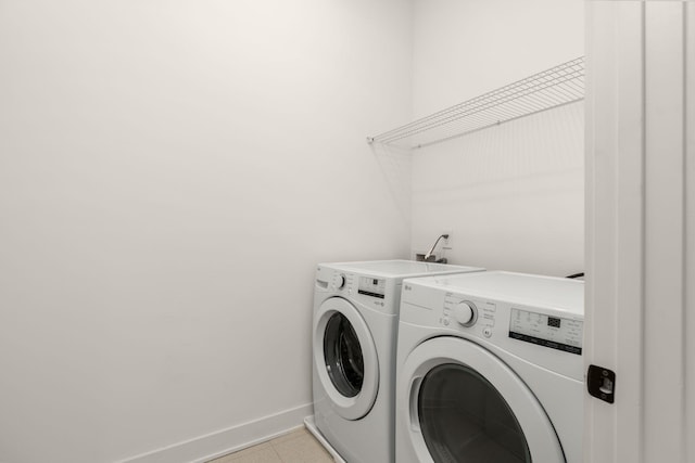 clothes washing area with light tile patterned flooring and independent washer and dryer