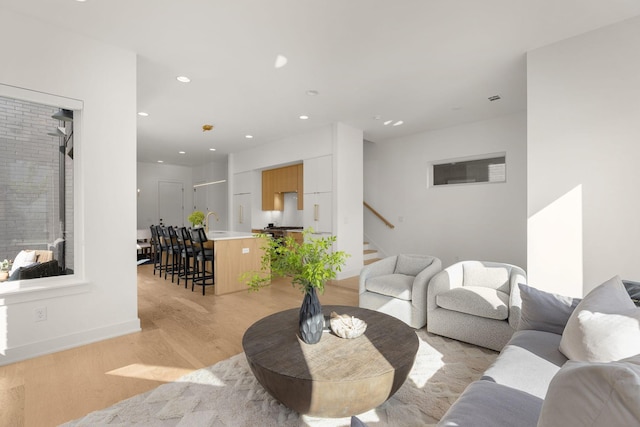 living room featuring sink and light hardwood / wood-style floors