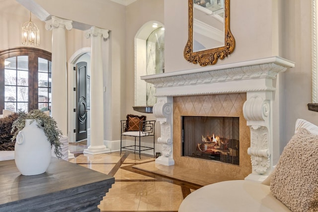 living area with an inviting chandelier, a high end fireplace, and decorative columns