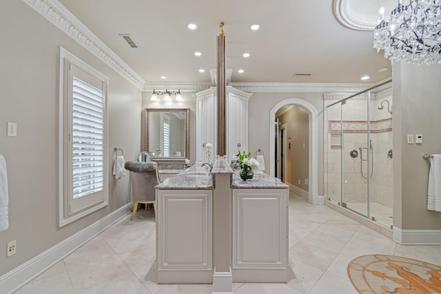 bathroom with tile patterned flooring, vanity, ornamental molding, a shower with door, and an inviting chandelier