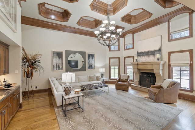 living room with ornamental molding, light wood-type flooring, and a wealth of natural light