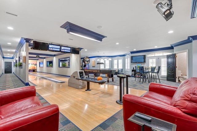 rec room with wood-type flooring, ornamental molding, and bowling