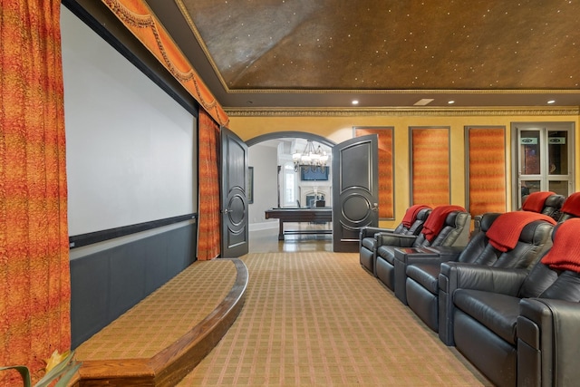 home theater with light colored carpet, ornamental molding, and a raised ceiling