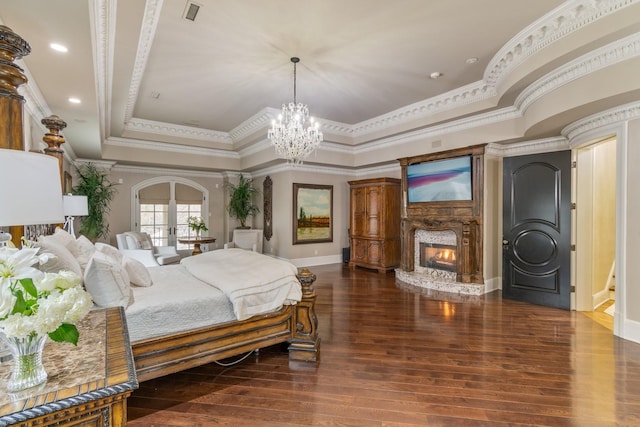 bedroom featuring french doors, ornamental molding, a raised ceiling, and dark wood-type flooring