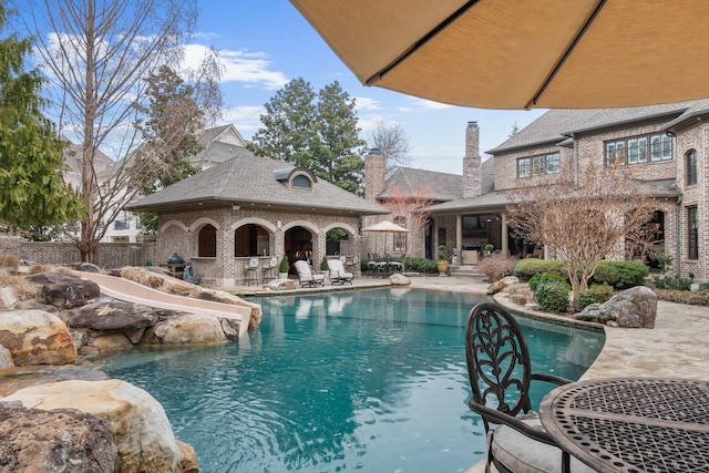 view of swimming pool featuring grilling area and a patio