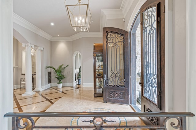 foyer with ornate columns, ornamental molding, and an inviting chandelier