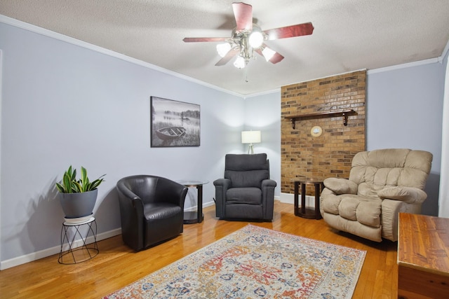 living room featuring ceiling fan, crown molding, wood-type flooring, and a textured ceiling