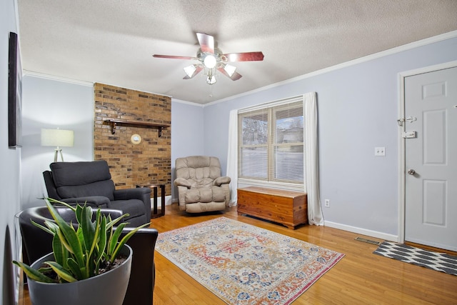 sitting room with ceiling fan, crown molding, wood-type flooring, and a textured ceiling