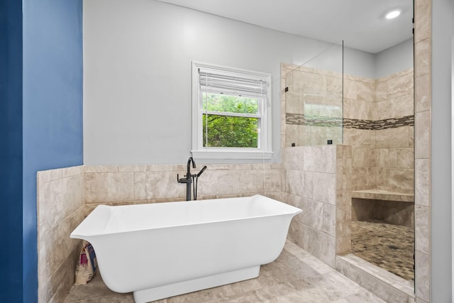 bathroom with tile walls, sink, and separate shower and tub