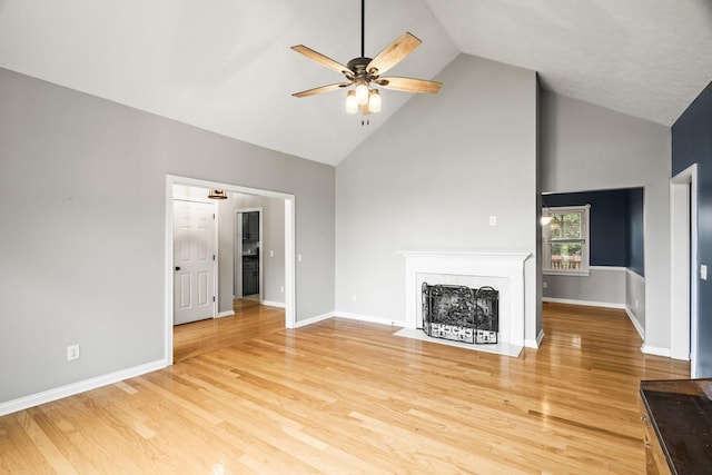 unfurnished living room featuring hardwood / wood-style flooring, ceiling fan, and high vaulted ceiling