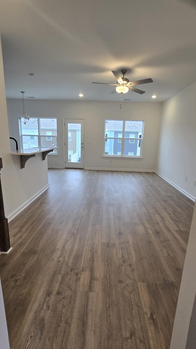 unfurnished living room featuring dark hardwood / wood-style flooring and ceiling fan