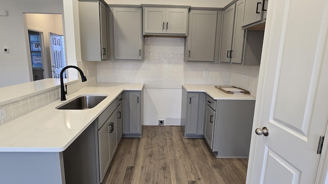 kitchen featuring tasteful backsplash, sink, dark wood-type flooring, and gray cabinets