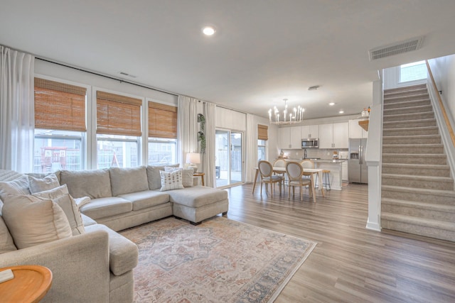 living room with a notable chandelier and light hardwood / wood-style floors