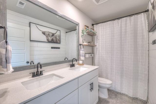 bathroom featuring tile patterned flooring, vanity, and toilet