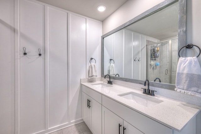 bathroom featuring tile patterned floors, a shower with shower door, and vanity