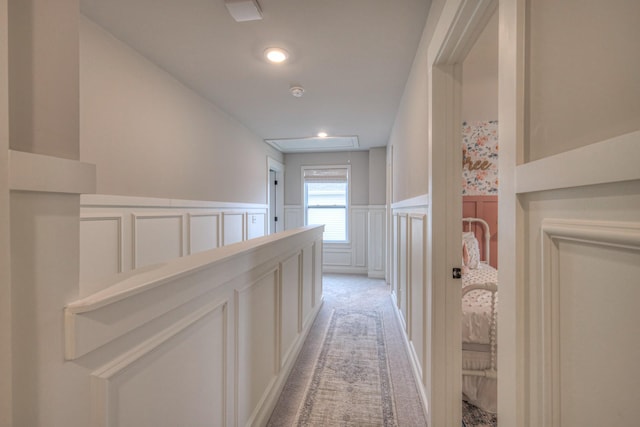 hall with light colored carpet