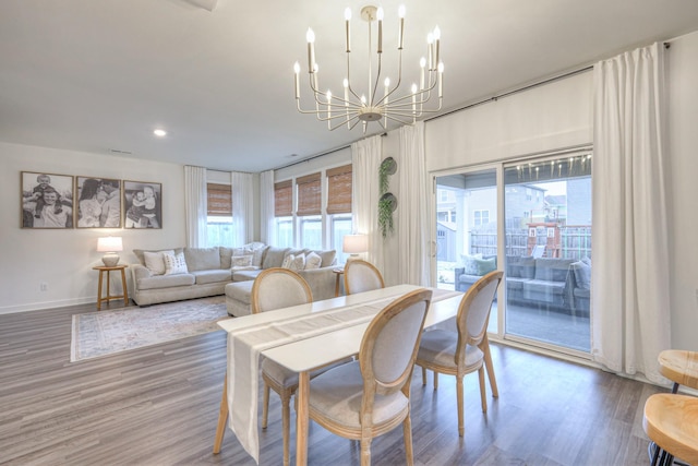 dining space featuring hardwood / wood-style flooring and a notable chandelier