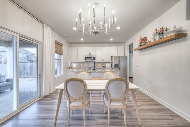 dining space featuring dark hardwood / wood-style flooring and a chandelier