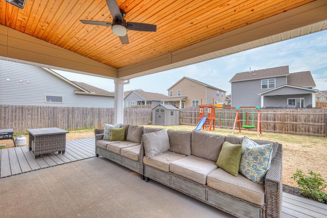 view of patio / terrace with a playground, a deck, ceiling fan, a shed, and an outdoor living space