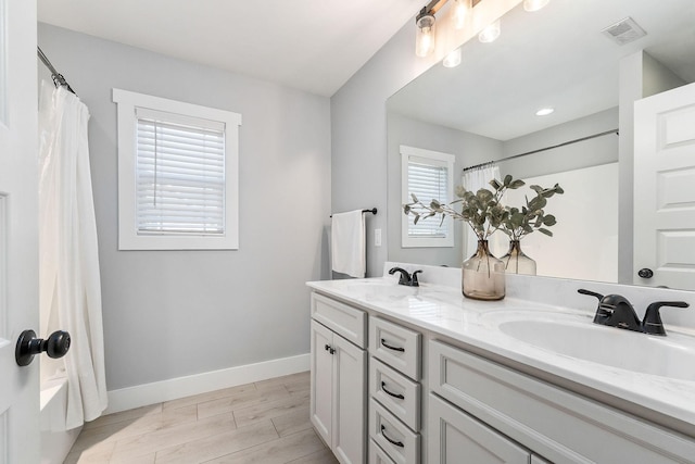 bathroom featuring shower / bath combination with curtain, vanity, and hardwood / wood-style floors