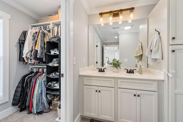 bathroom featuring ceiling fan, ornamental molding, and vanity