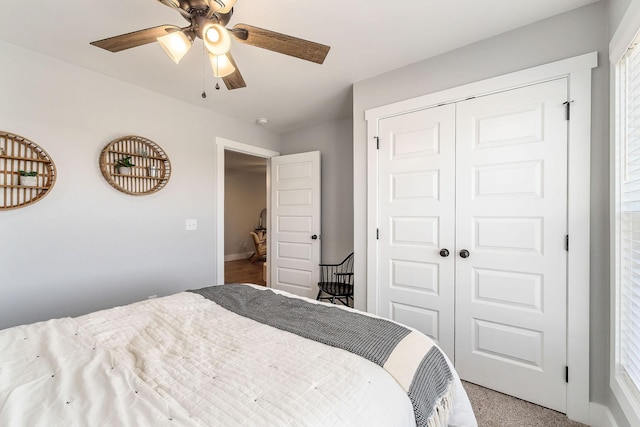 carpeted bedroom with ceiling fan and a closet