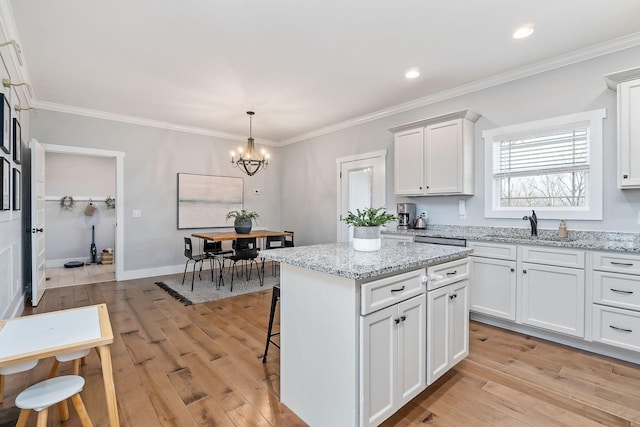 kitchen featuring white cabinetry, a kitchen island, and sink