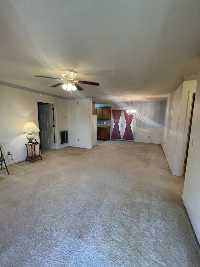 interior space featuring light colored carpet and ceiling fan with notable chandelier