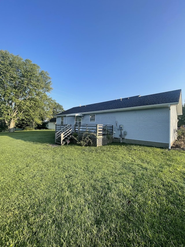 back of house with a deck and a lawn