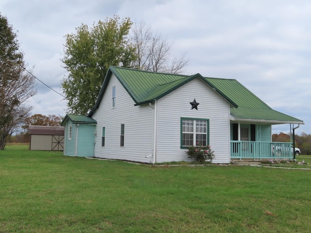 exterior space featuring a yard, covered porch, and a storage shed