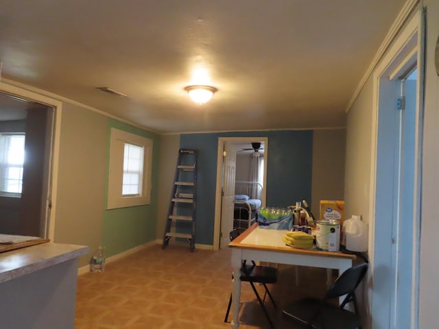 interior space with ornamental molding, plenty of natural light, and light parquet flooring