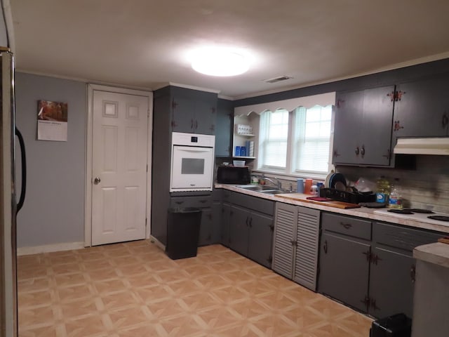 kitchen featuring tasteful backsplash, sink, white appliances, and ornamental molding