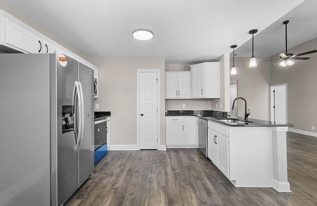 kitchen featuring dark hardwood / wood-style floors, sink, white cabinets, kitchen peninsula, and stainless steel appliances